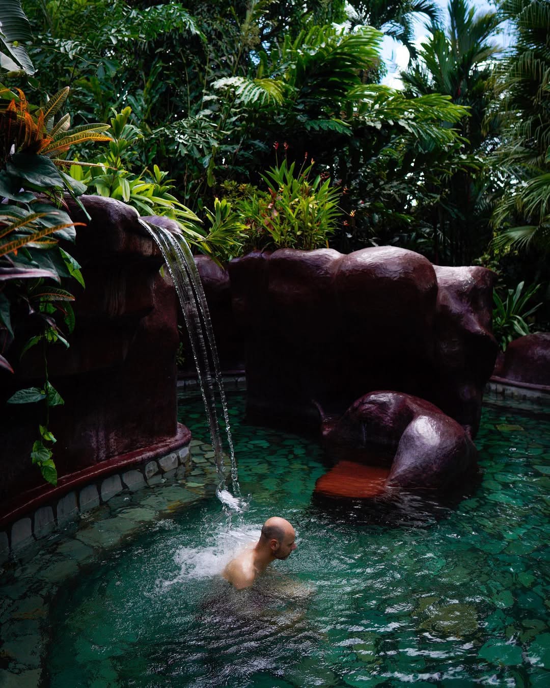 Travelers relaxing in natural hot springs during a thermal therapy tour